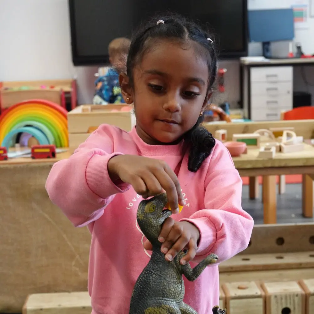 Young girl playing with dinosaurs