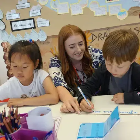 Teacher helping students write