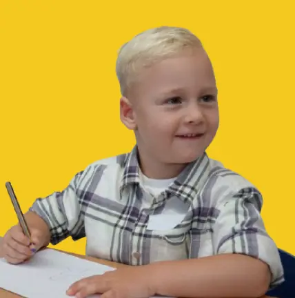 Young student sitting at desk and writing