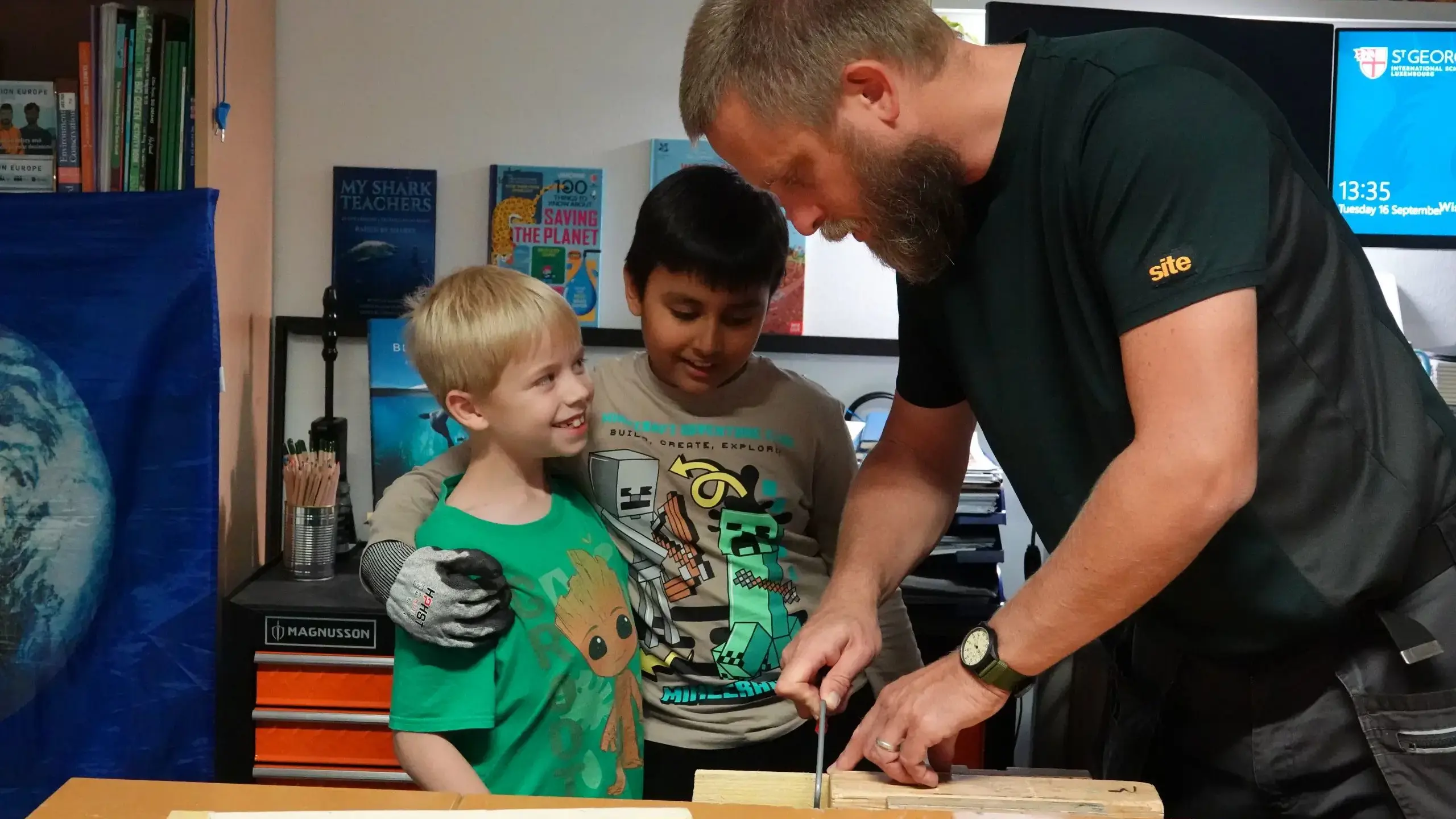 Teacher helping children with woodwork